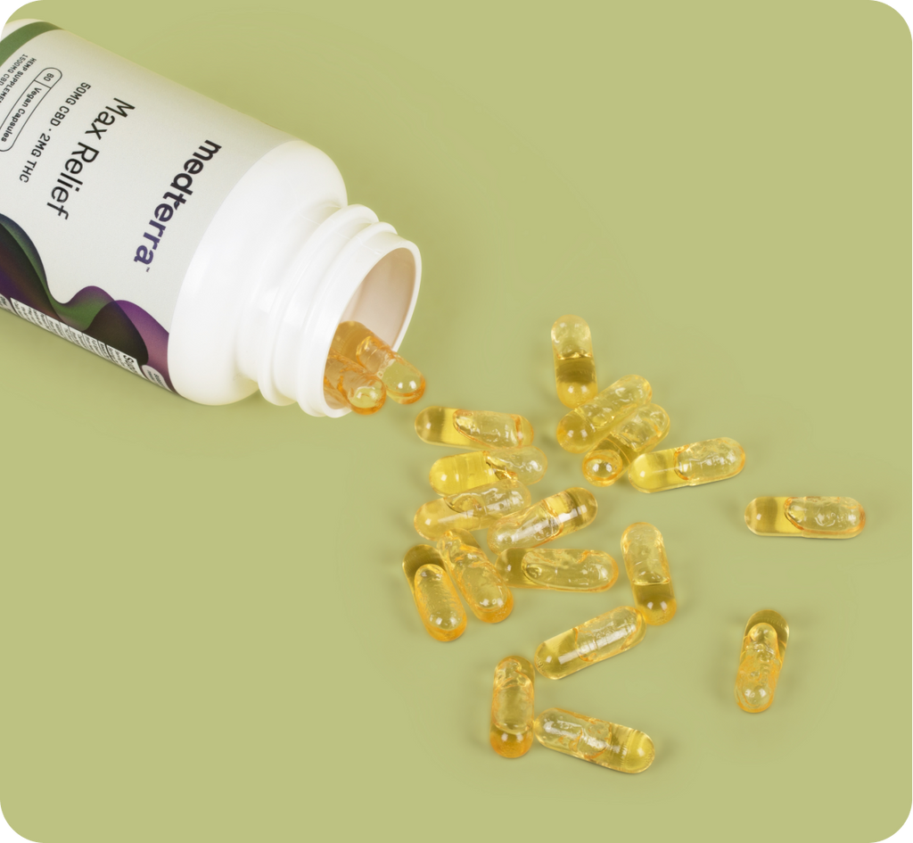 A white bottle labeled "microterra Max Relief" lies on its side, spilling numerous yellow, transparent capsules onto a light green surface. The shiny capsules suggest they contain liquid and boast a vegan formula infused with Full Spectrum CBD Oil for enhanced effectiveness.