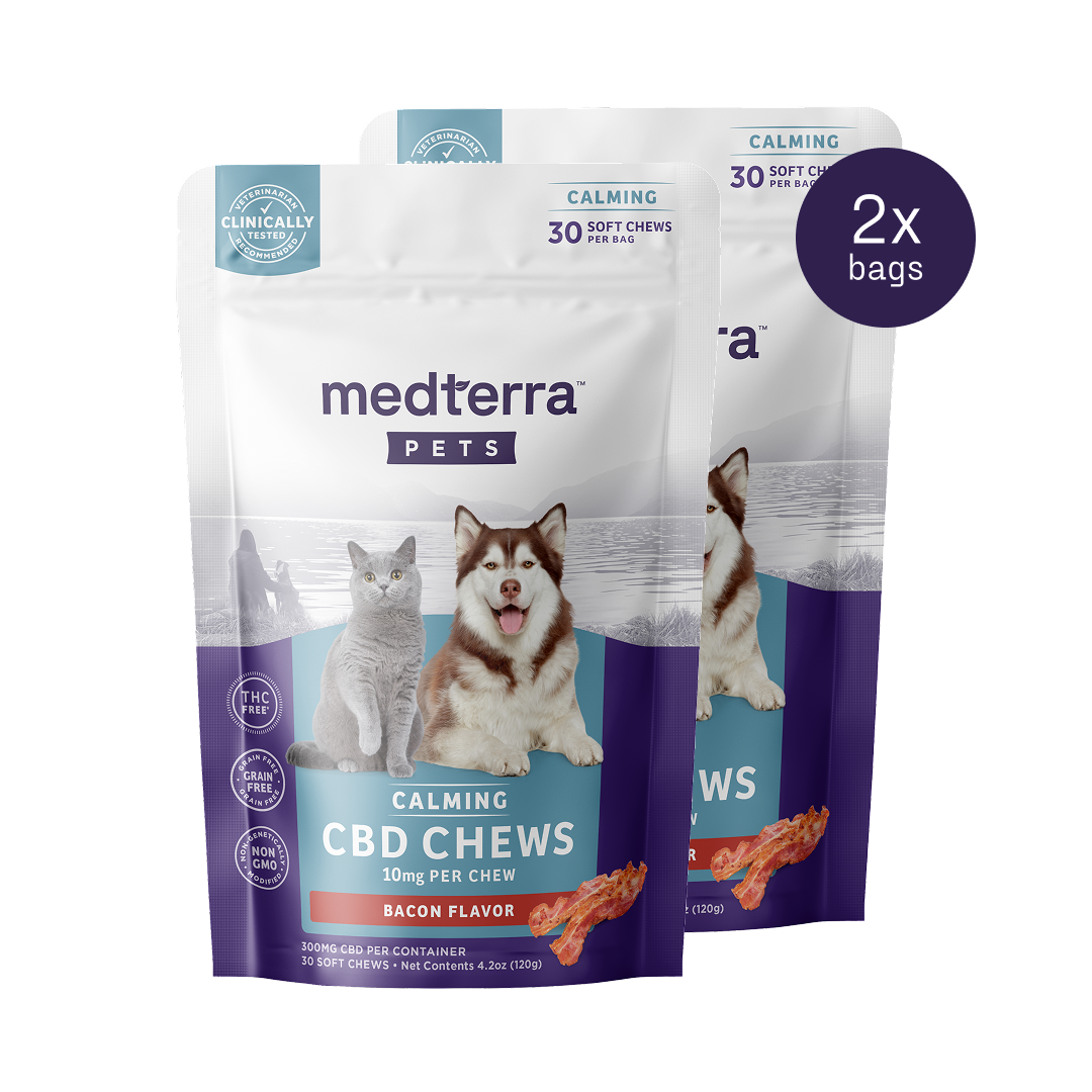Two packs of Medterra's Pet CBD Calming Chews are displayed, each containing 30 bacon-flavored soft chews with 10mg of Pet CBD and L-Tryptophan per chew. The package showcases a cat and a dog, highlighting calming benefits and clinical testing.