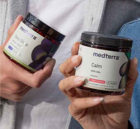 Two jars of Medterra products: one labeled 'Deep Sleep' and the other 'Calm,' both with colorful designs and held in hands.