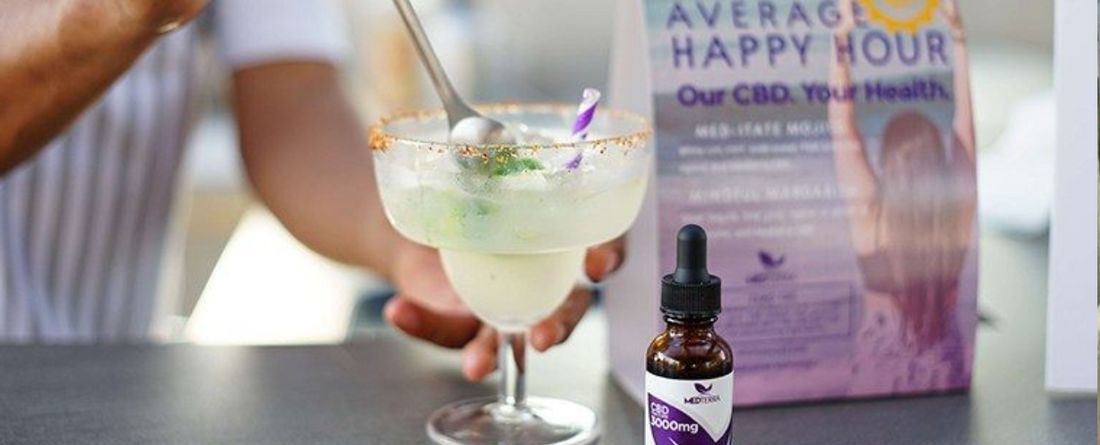 Cocktail glass with a spoon and purple-striped straw, a dropper bottle labeled 'CBD 3000mg', and a blurred sign reading 'AVERAGE HAPPY HOUR Our CBD. Your Health.'