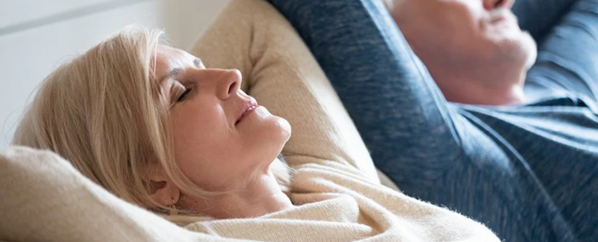 A woman and a man relaxing with eyes closed, suggesting calmness and rest.