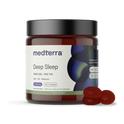 A jar labeled "Deep Sleep CBD Gummies" by Medterra, containing 20 mixed berry gummies, is shown. The product includes 25mg of CBD and melatonin, 2mg THC, and Full Spectrum Hemp Extract. The dark-colored jar with a black lid features abstract green and blue designs. Three gummies are placed beside it.