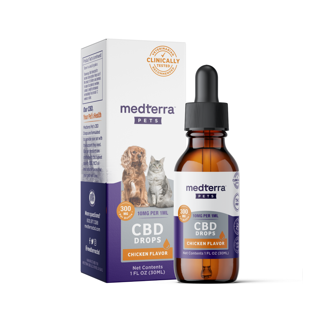 A brown glass dropper bottle labeled "Medterra Pet CBD Drops, Chicken Flavor" is placed in front of its box. The box, featuring images of a dog and a cat, highlights "300mg CBD" and "Clinically Tested." It boasts natural beef and chicken flavorings with organic ingredients. Net contents: 1 fluid ounce (30 mL).