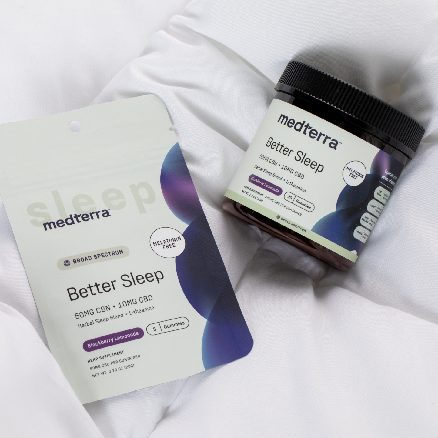 Medterra’s Better Sleep TruCBN® Gummies Sample Pack jar and packaging sit on a white, quilted surface. The labels highlight the blackberry lemonade flavor and feature both CBN and CBD.
