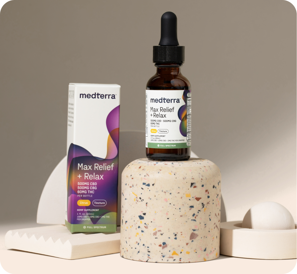 A bottle of Medterra Max Relief + Relax Full Spectrum CBD Tincture stands on a speckled cylindrical pedestal, promising a mood boost. Next to it is the product's white and purple box. The background consists of minimalist geometric shapes in neutral colors.