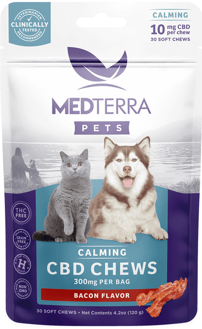 A white and purple package of Medterra [Free] Best Seller Pets Calming CBD Chews. The front of the package features images of a gray cat and a brown and white dog. It states "10 mg per chew," "300 mg per bag," and "Bacon Flavor." Contains 30 soft chews, net weight 4.2 oz.