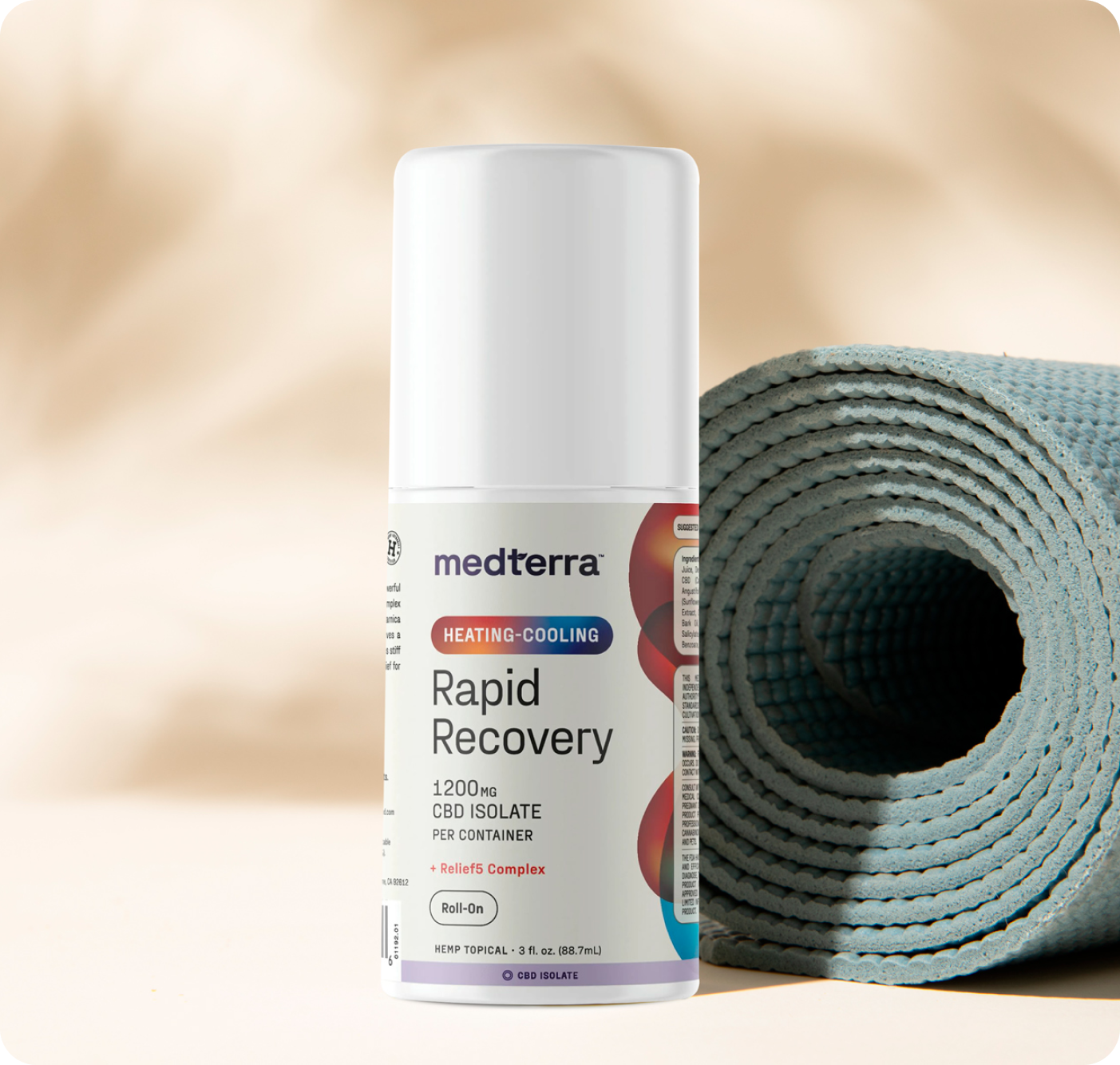 A Medterra Heating-Cooling Rapid Recovery Roll On stands upright beside a rolled-up blue yoga mat on a beige surface, with a soft, neutral background—showcasing convenient pain relief for your active lifestyle.