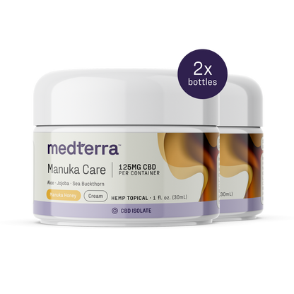 Two containers of Medterra’s Manuka Care Cream are shown, each labeled "1.25MG CBD per container," "Aloe • Jojoba • Sea Buckthorn," and "Manuka Honey." A label at the top right indicates "2x bottles," showcasing this effective skincare duo.
